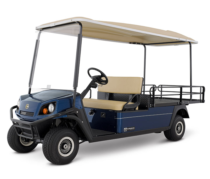 Blue Cushman flat cargo golf cart with a tan roof in front of a blank white background.